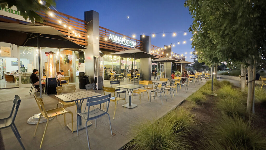 well-lit, active exterior eating area at sundown near restaurants at Tasman Tech